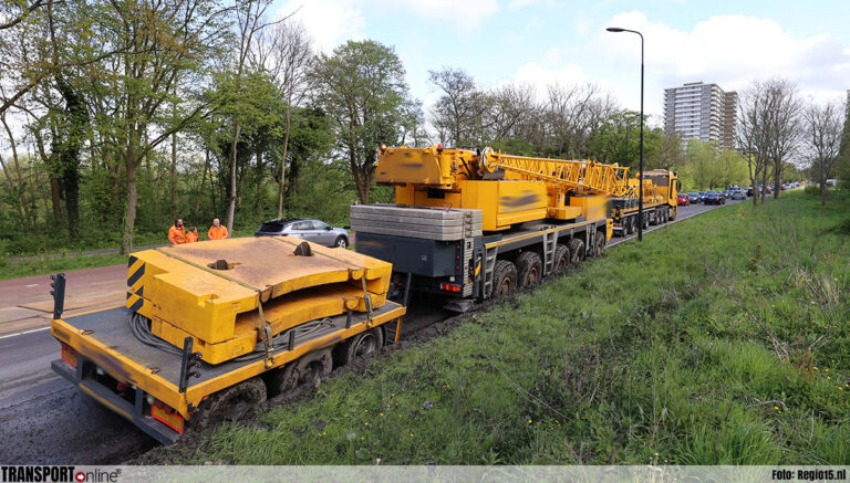 Kraan raakt van de weg en komt vast te zitten in berm [+foto]