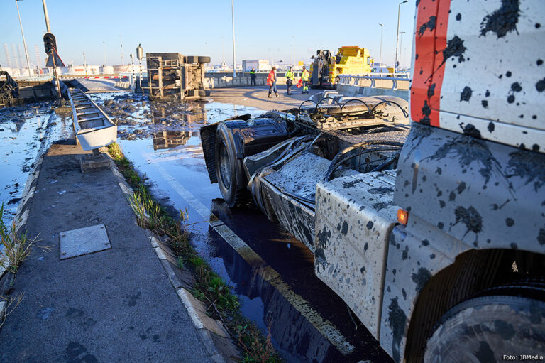 Oplegger kantelt op rotonde over A15, inhoud komt op onderdoor rijdende vrachtwagen terecht [+foto’s]