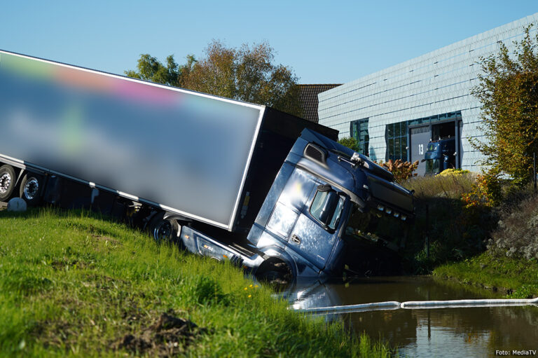 Mogelijk onwel geworden vrachtwagenchauffeur rijdt water in bij bedrijf