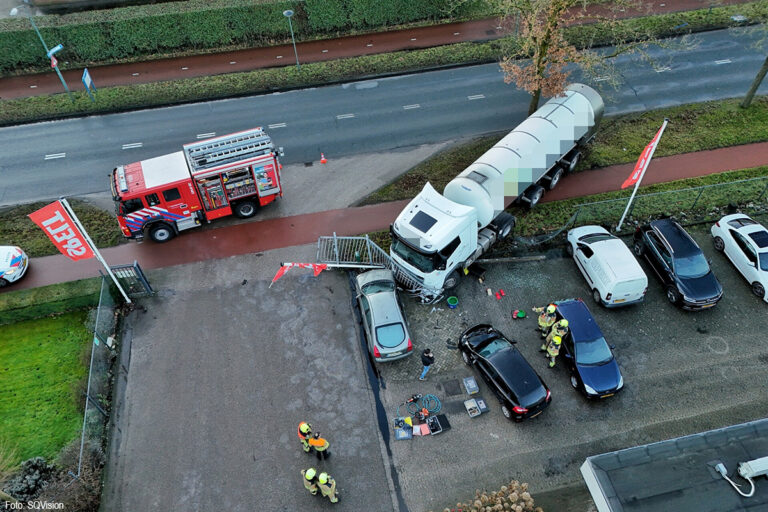 Vrachtwagen rijdt door hek bedrijf en ramt auto’s