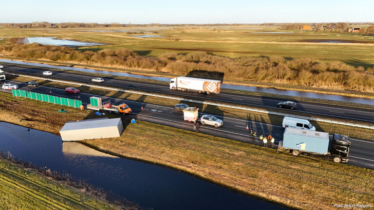 Vrachtwagen aanhanger met botsautootjes gekanteld op A7
