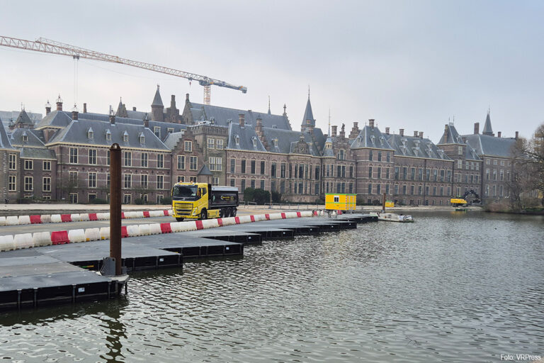 Vrachtwagens rijden over de Hofvijver voor het storten van zand