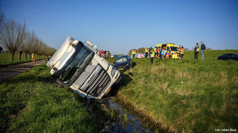 Vrachtwagen na aanrijding met auto in de sloot langs A50