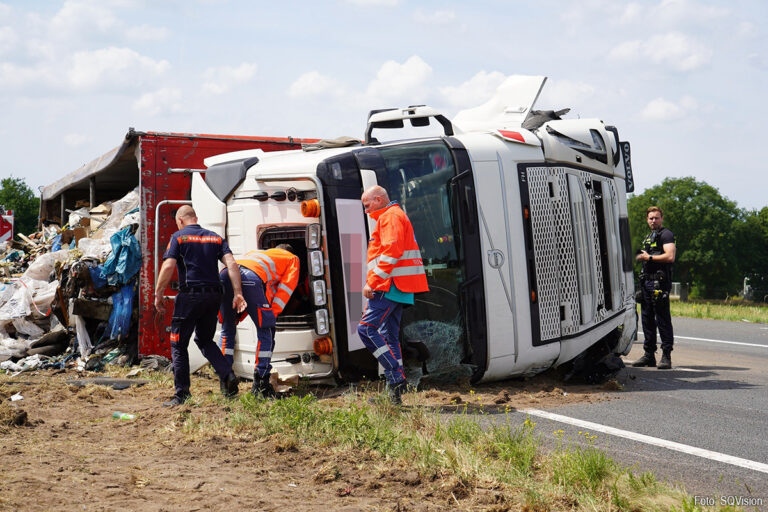 Vrachtwagen met afval na klapband gekanteld op A58