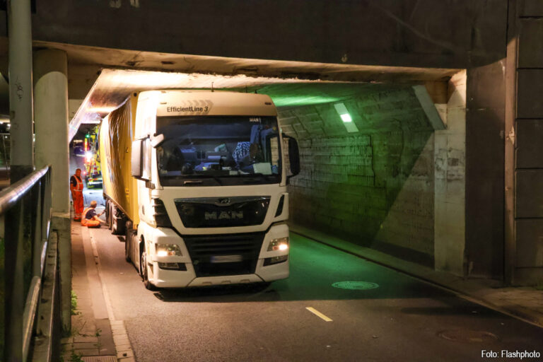 Vrachtwagen met container klem onder tunnel in Rotterdam