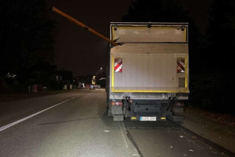 Houten balk steekt na onbekend ongeval uit geparkeerde vrachtwagen