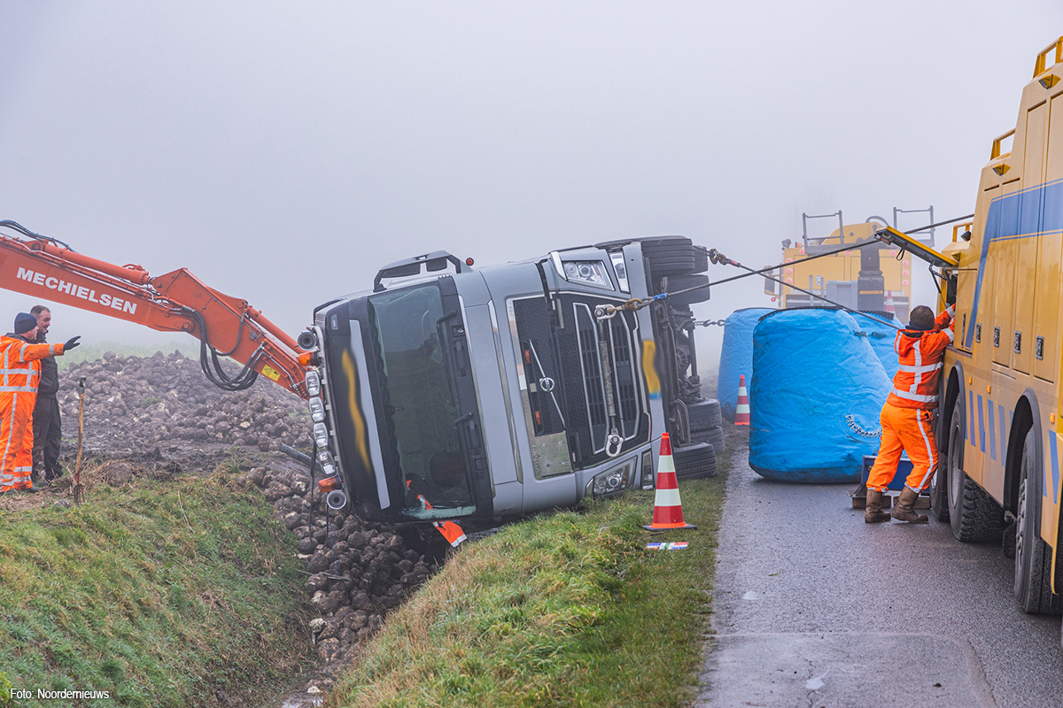 Vrachtwagen met suikerbieten in sloot gekanteld bij Lauwerzijl, chauffeur gewond