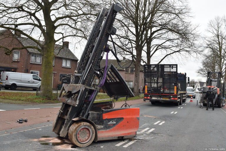 Heftruck valt van vrachtwagen na aanrijding tegen spoorviaduct in Waardenburg