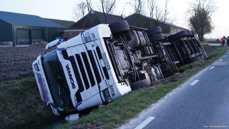 Vrachtwagen in de sloot langs smalle weg bij Huizinge