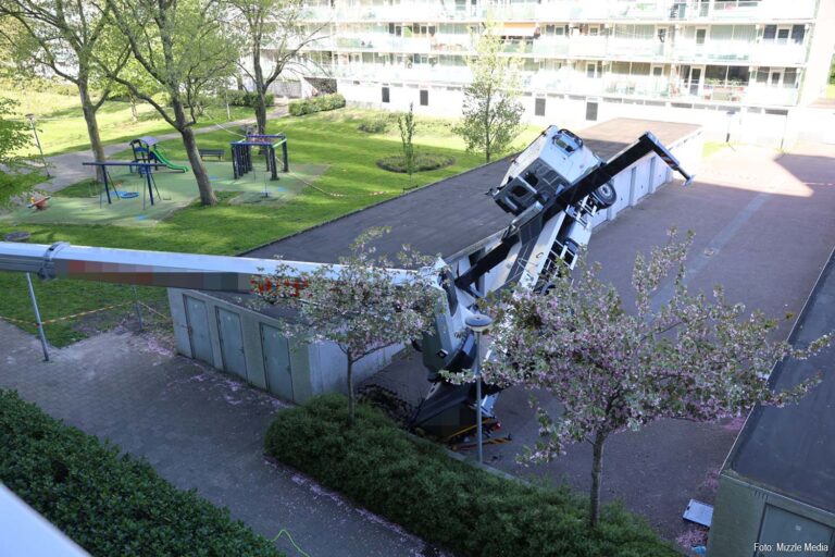Vrachtwagenhoogwerker zakt door grond en komt scheef te hangen bij Monnetflat in Uithoorn