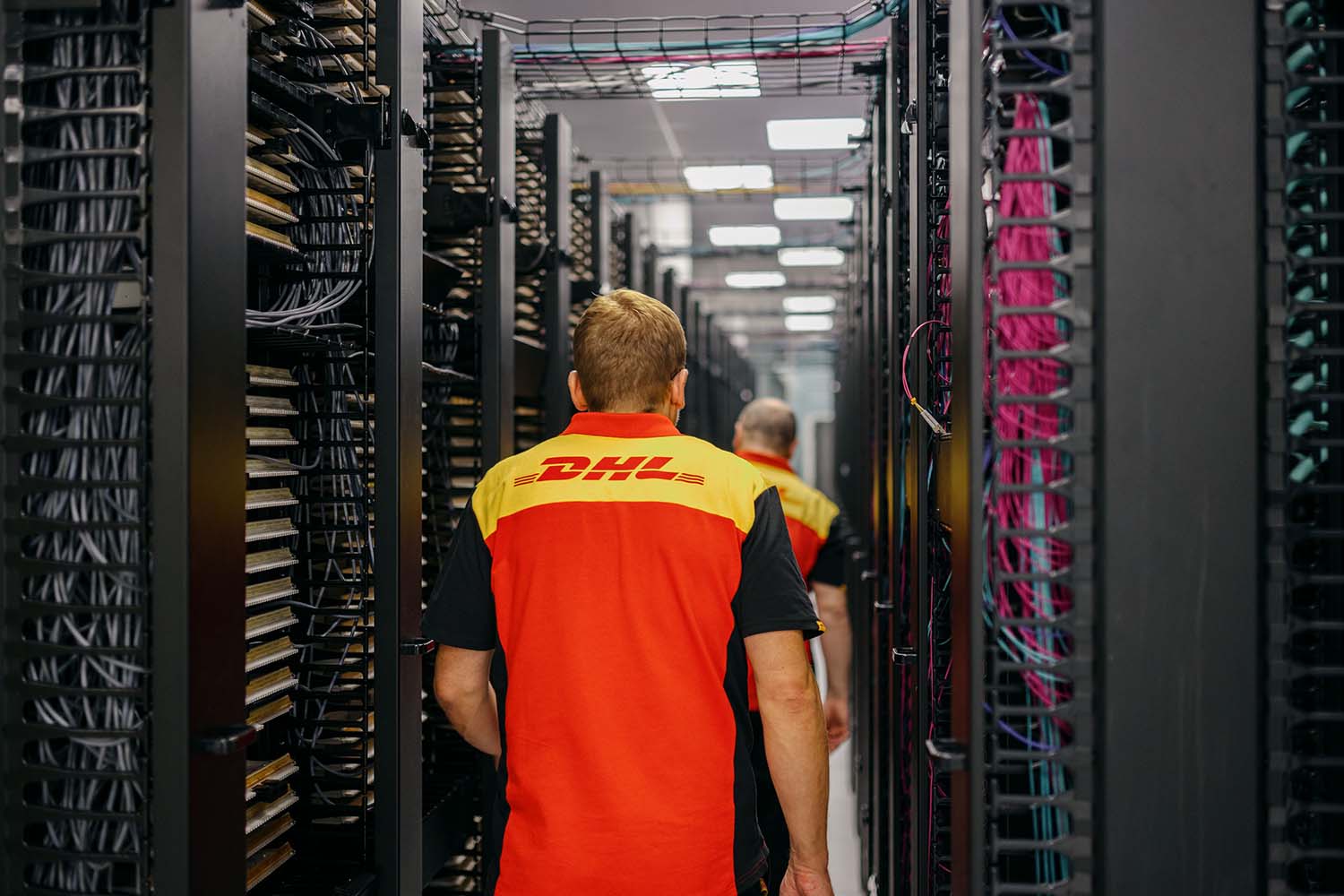 Two colleagues walking down corridor of server racks