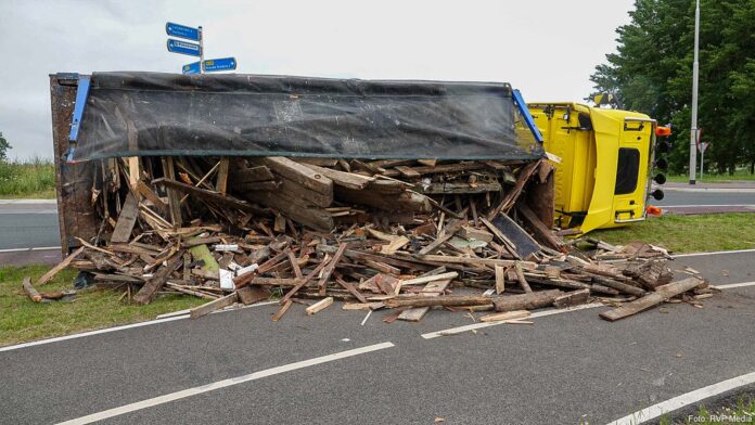 Vrachtwagen met hout gekanteld
