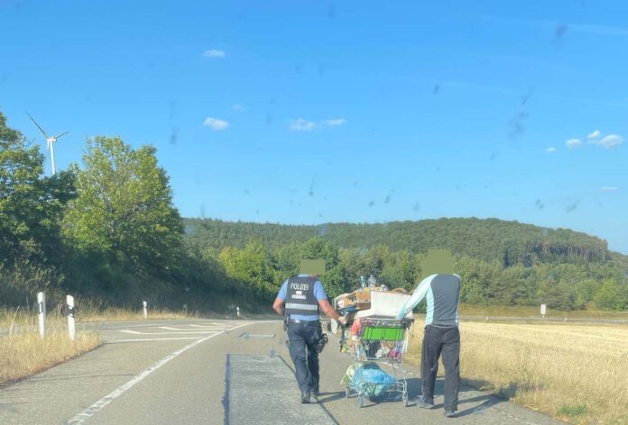 man op vluchtstrook met winkelkarretje