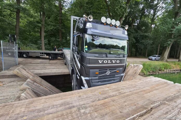 Vrachtwagen zakt door brug