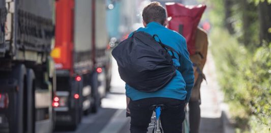 fietsers naast vrachtwagen